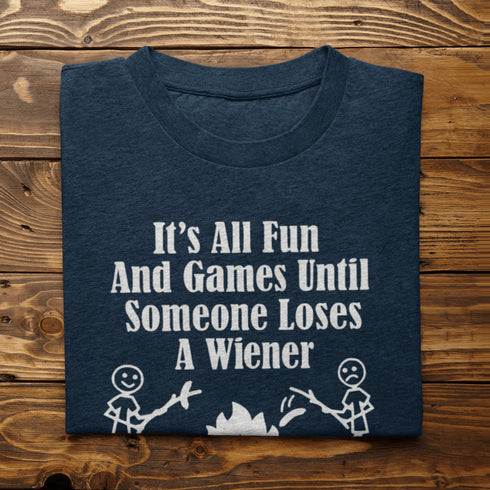 Our Camping tee features two adorable stick figure people roasting wieners over a cozy campfire. And with the hilarious slogan "It's All Fun & Games Until Someone Loses A Wiener," you'll be the life of the party at any camping trip!
